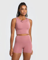 وصف: امرأة ترتدي قميص بلا أكمام Essential Crop Tank Top بلون وشورت الجسم السكني من WOMEN'S BEST - Dusty Pink.